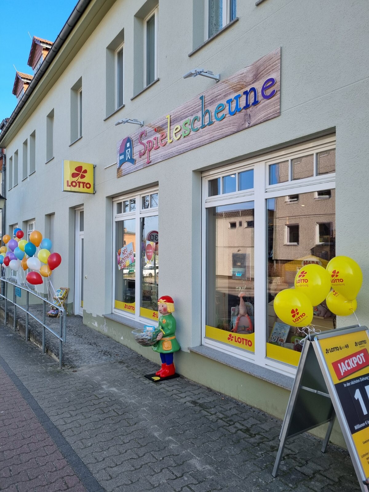 Schaufenster der Spielescheune mit bunten Luftballons